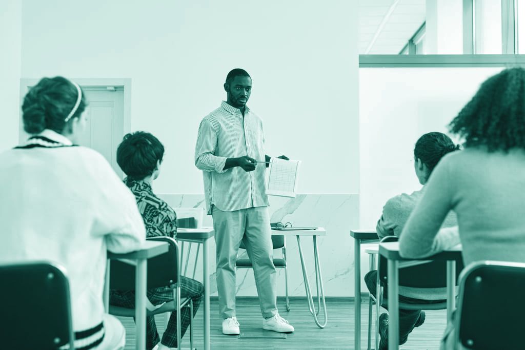 En lärare presenterar kursmaterial för en grupp studenter i ett klassrum