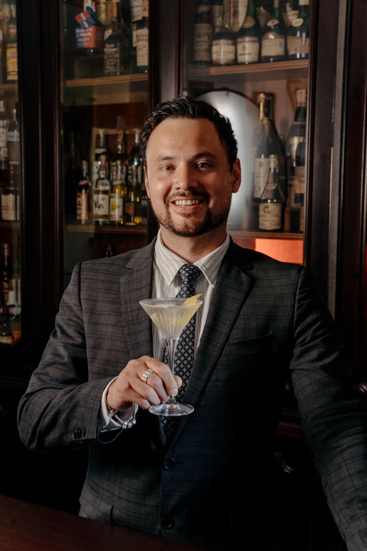Portrait of Andy Watson at a bar, holding a martini