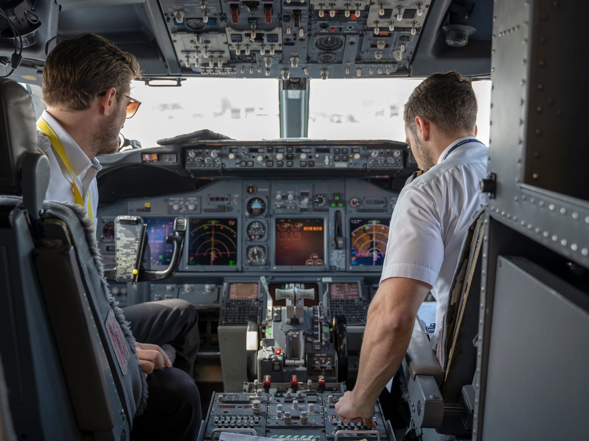 Two pilots at the controls in the cockpit of an airliner