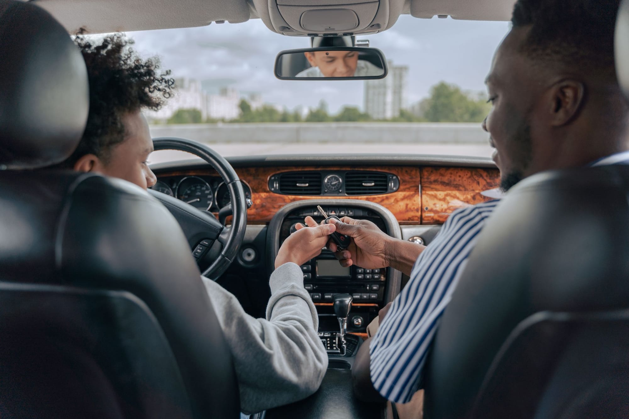 An instructor handing the car keys to a learner driver