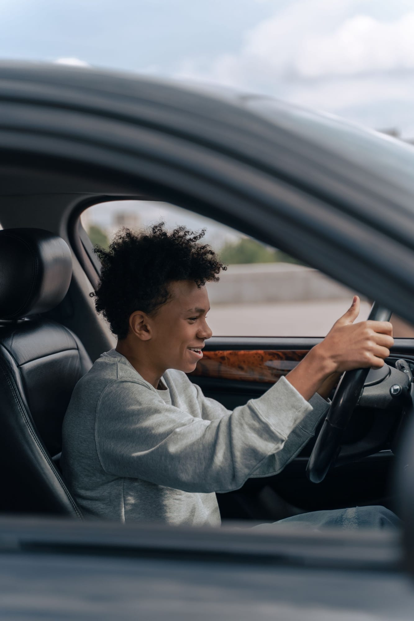 A smiling teenager learning to drive