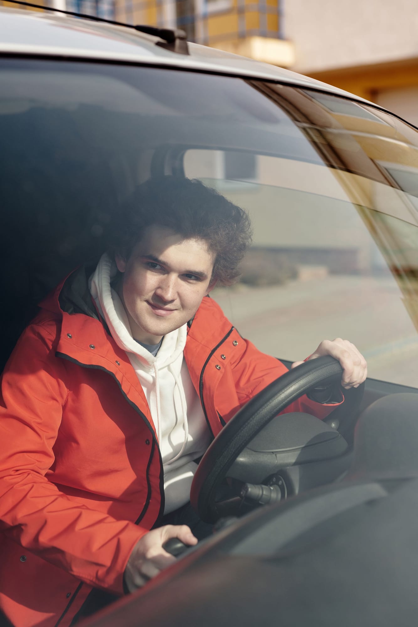 A young driver smiling behind the wheel