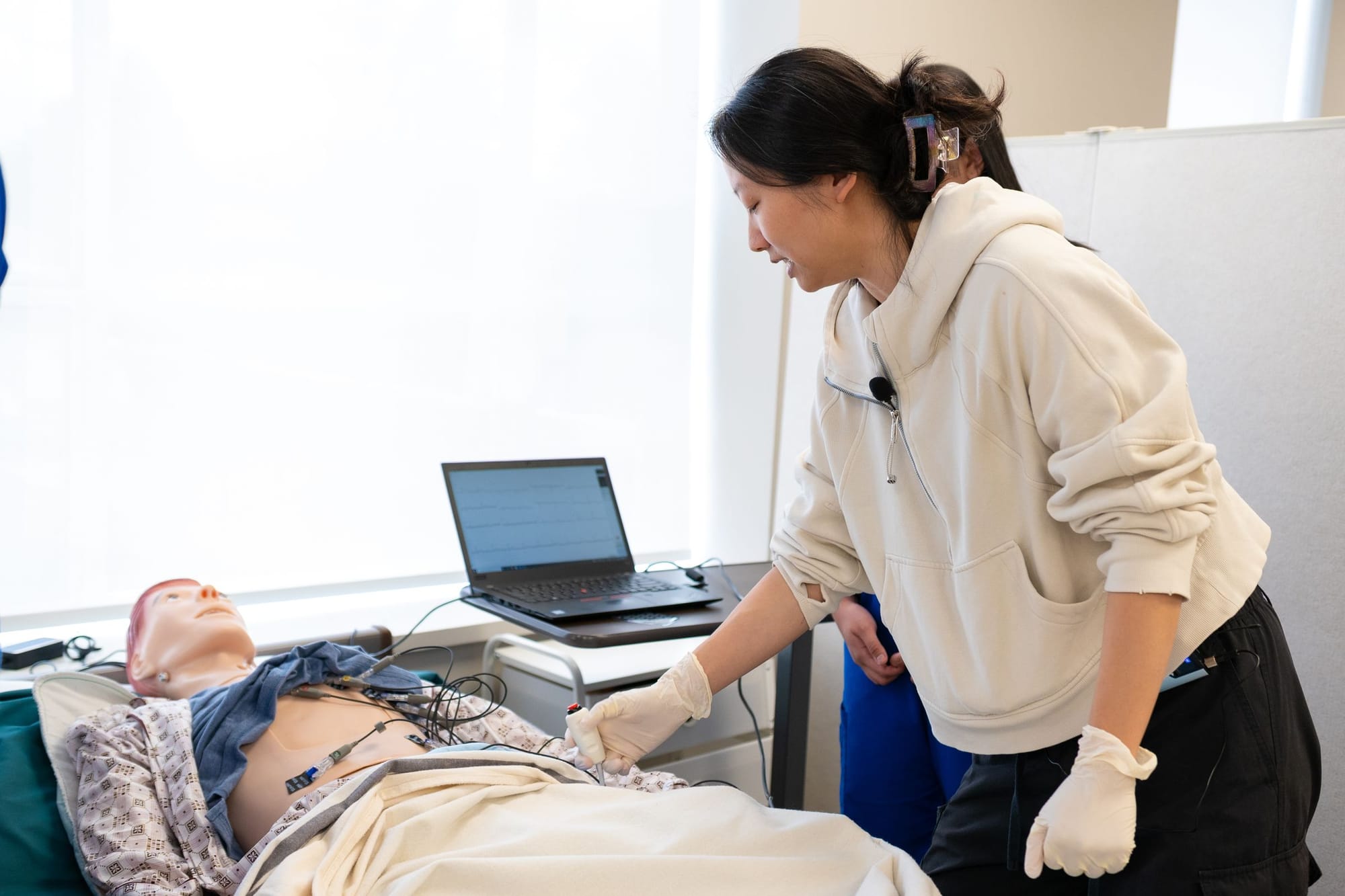 A student practising on a simulation manikin in a training room
