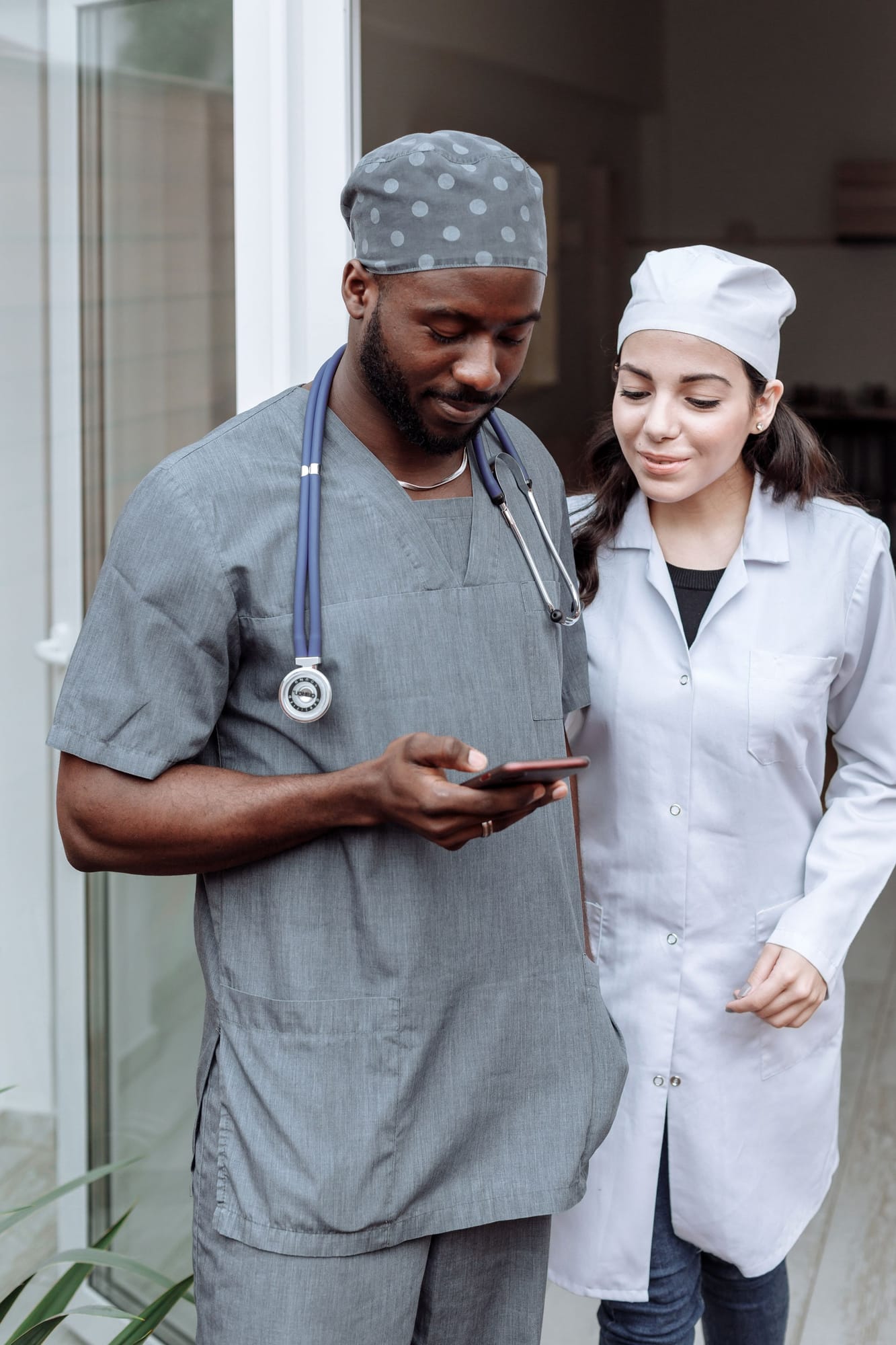 A nurse and a doctor looking at a phone together