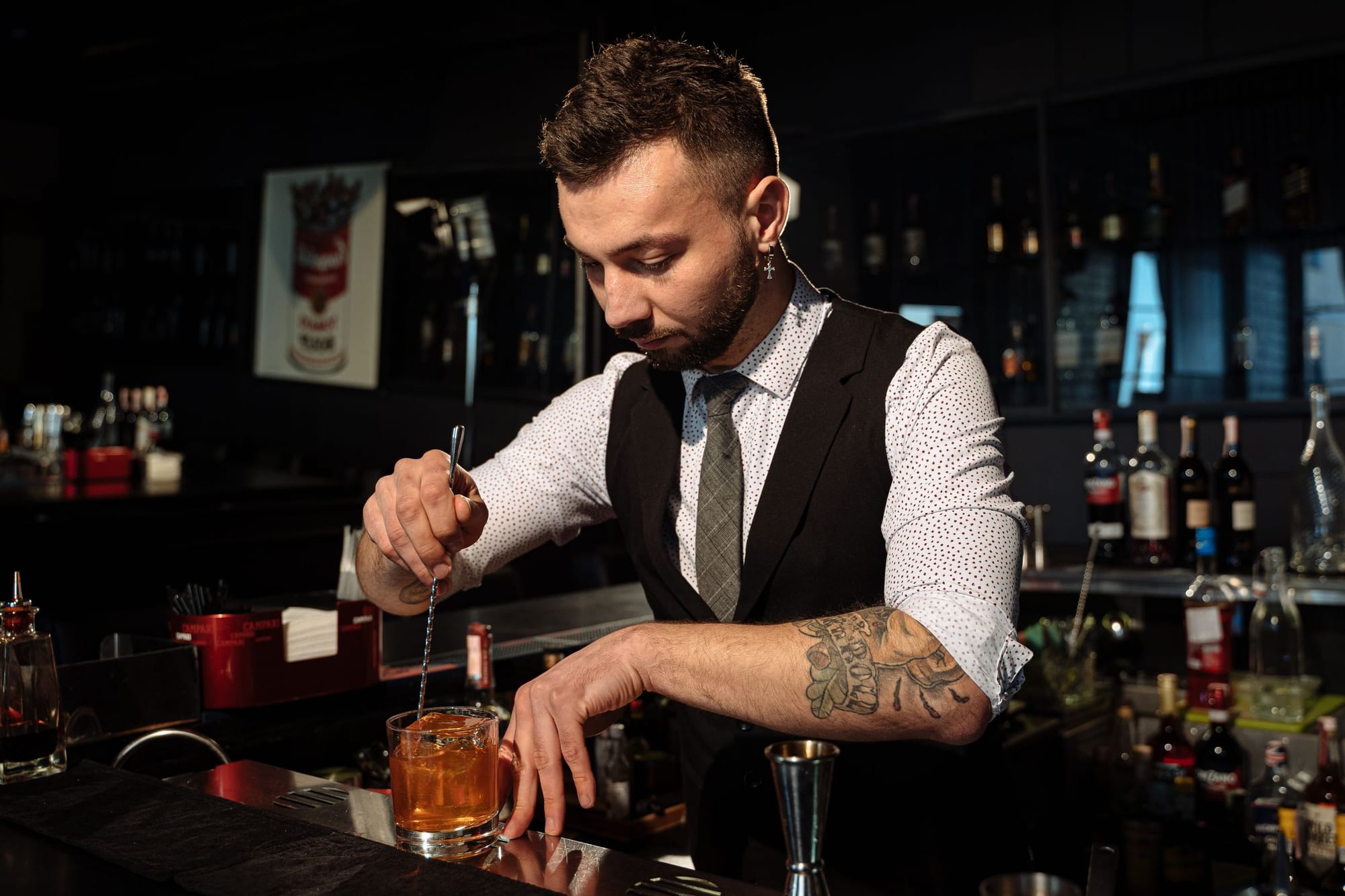 A bartender stirring a cocktail behind the bar