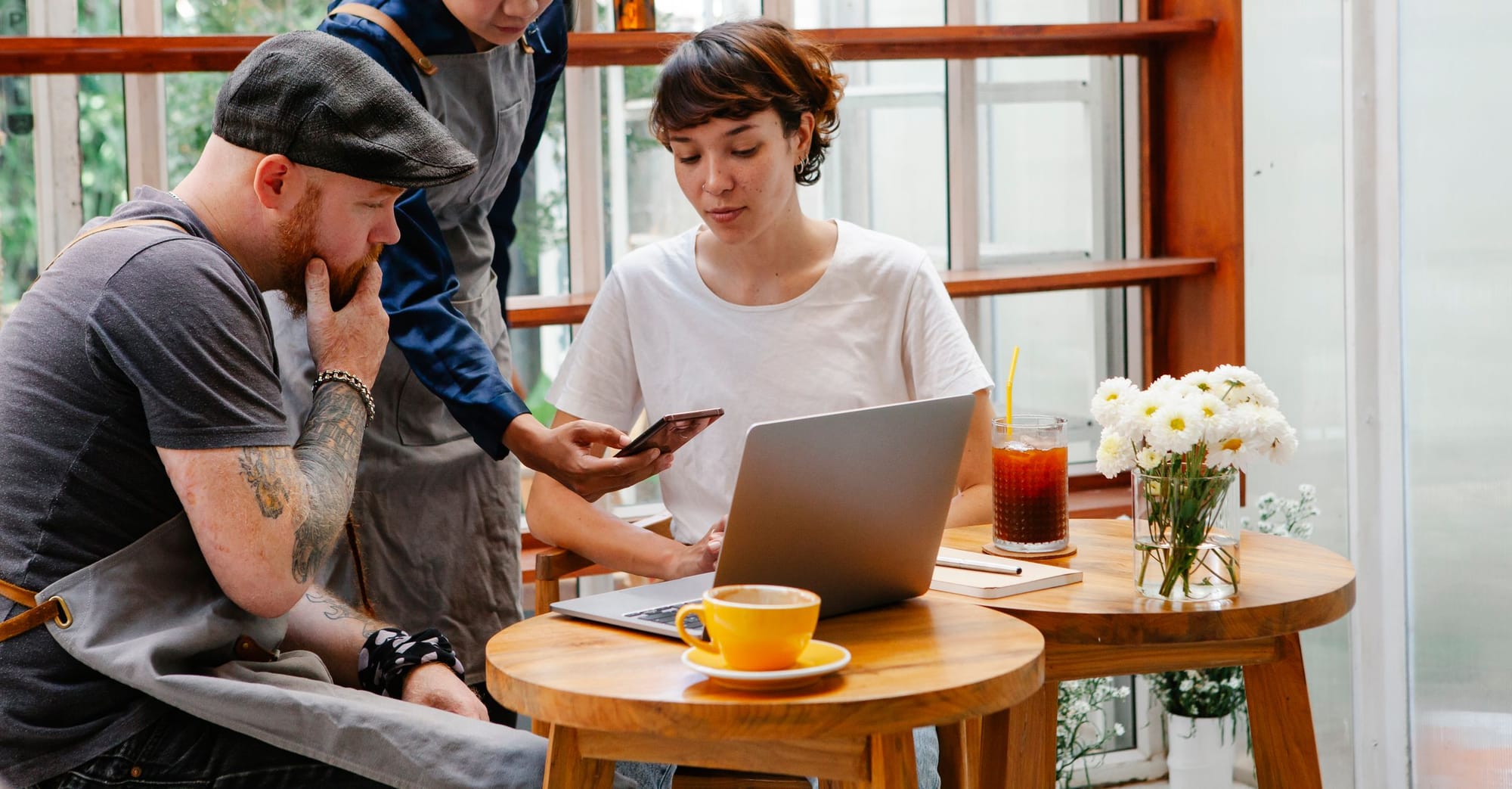 Café staff planning around a laptop and a phone