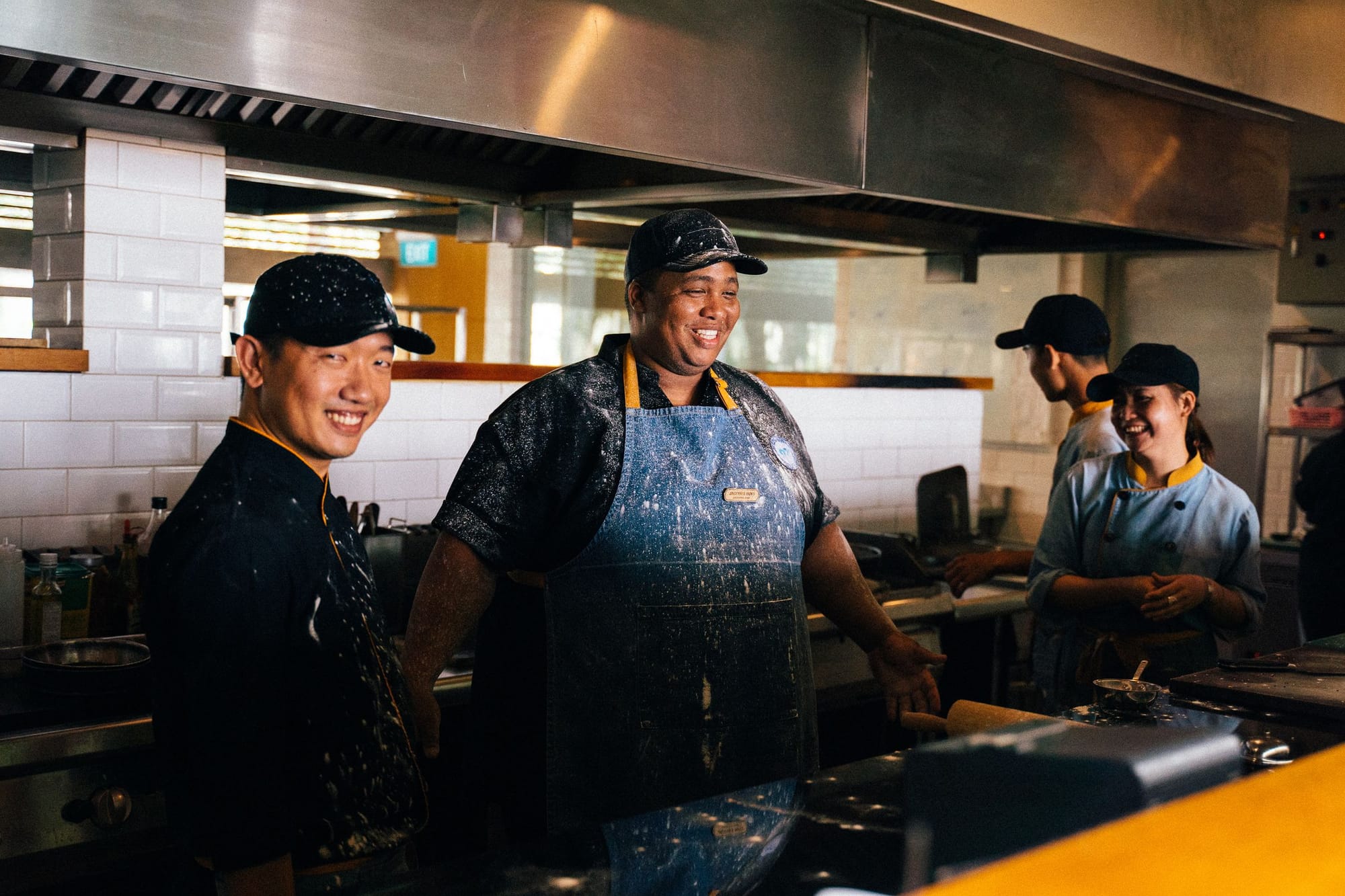 A smiling kitchen team at work in a restaurant kitchen