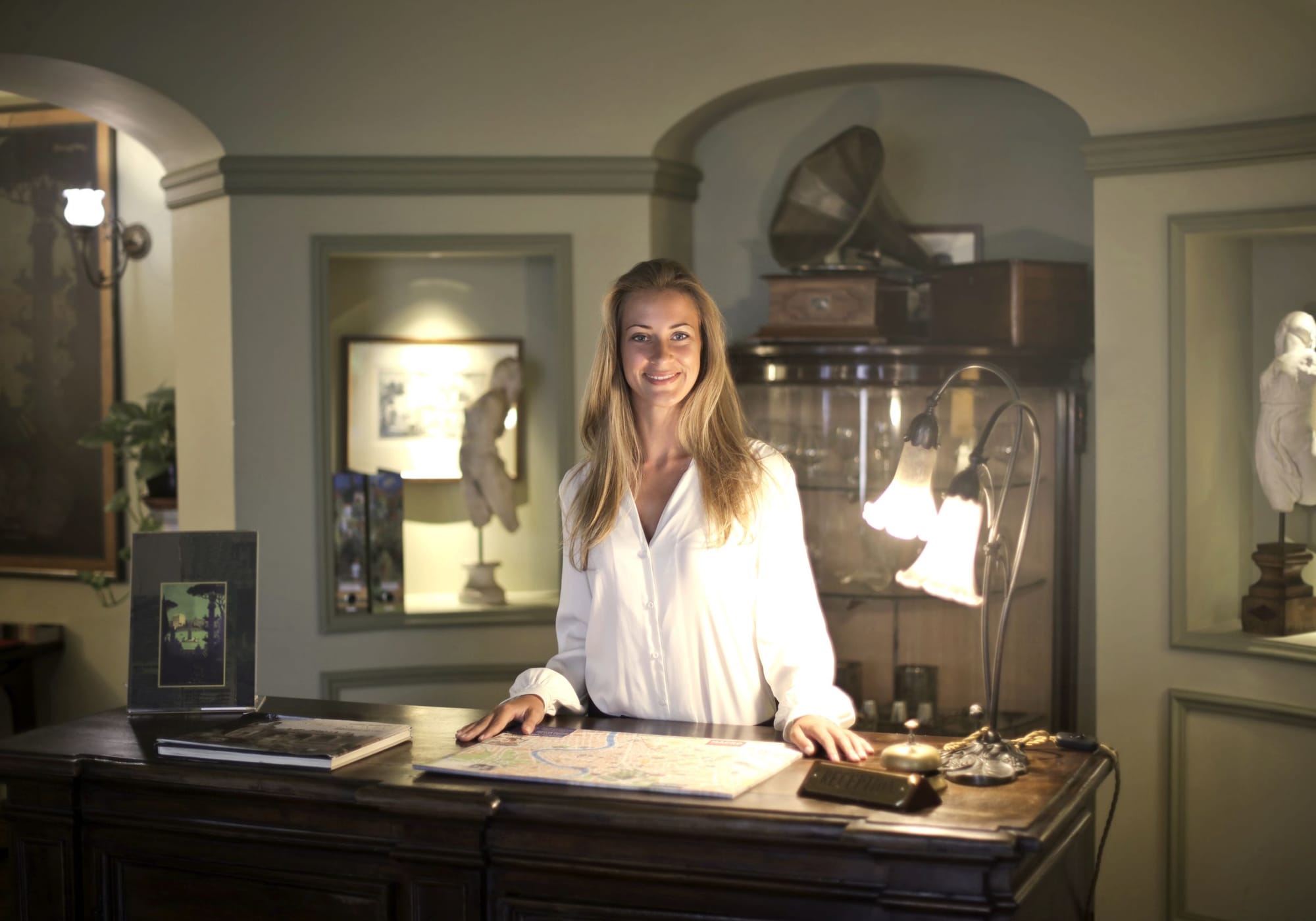 A receptionist smiling behind a hotel front desk