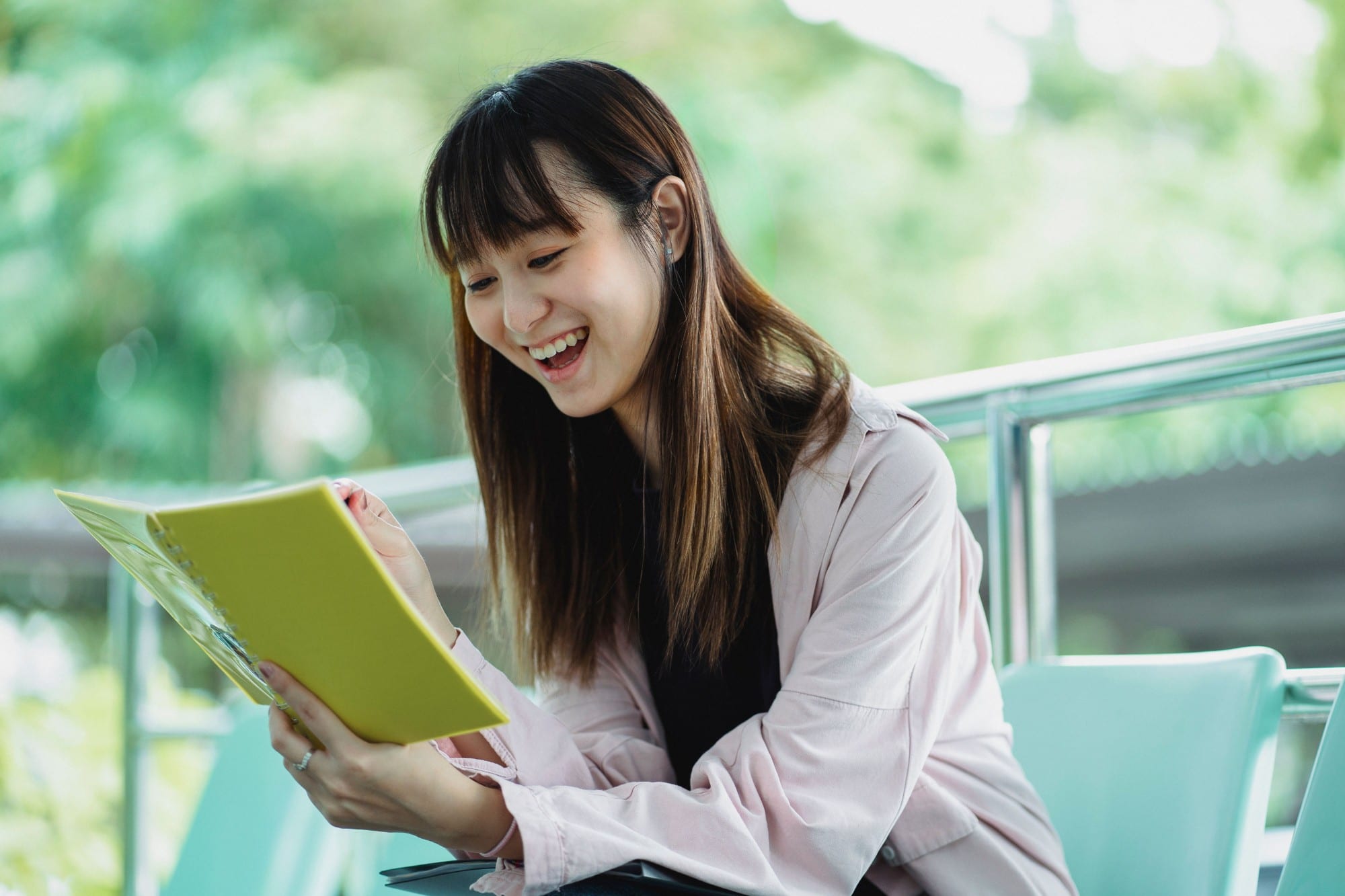 A student laughing as she reads her notebook