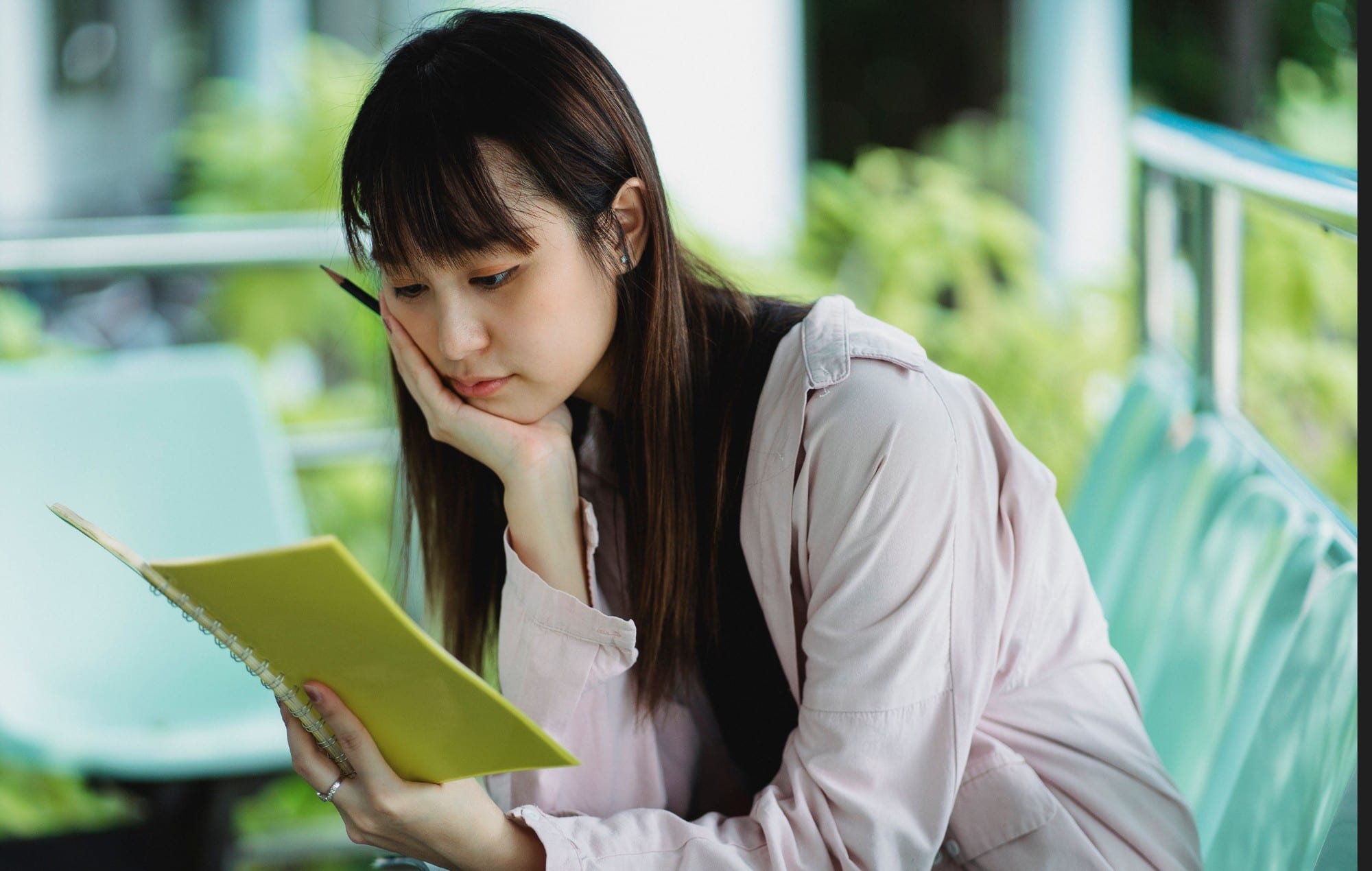A student thinking over her notebook