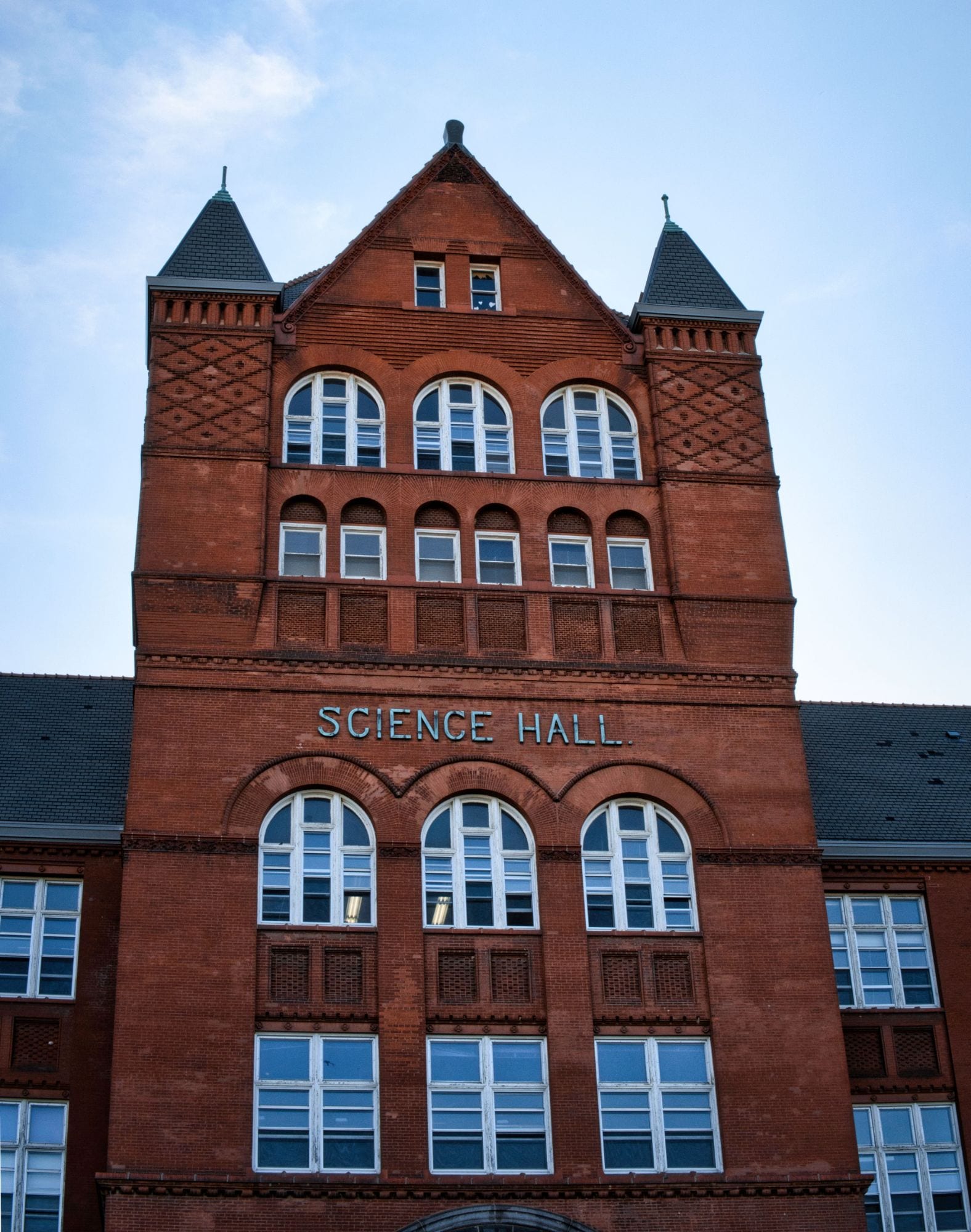 A red-brick university building against a blue sky