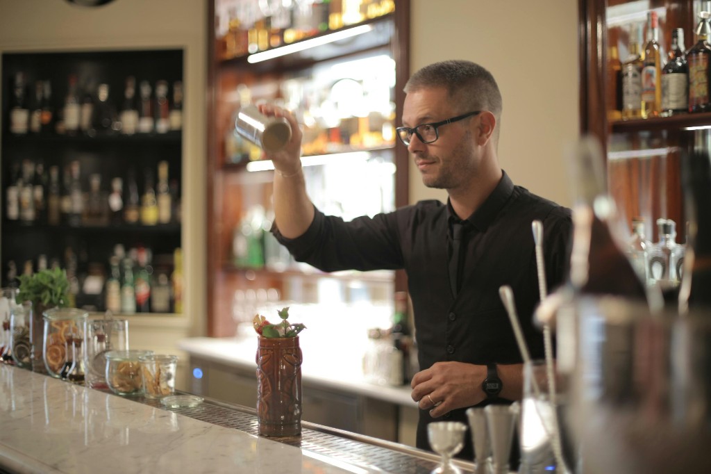 Bartender shaking a cocktail behind a professional bar